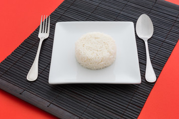 cooked rice with a spoon and fork on white dish