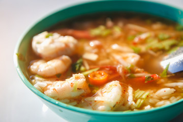 vegetable spicy soft boiled gruel rice with shrimp and squid on white background, breakfast Asian food, Thai food, Selective focus