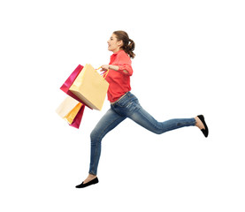 smiling young woman with shopping bags jumping