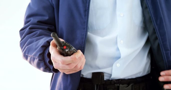 Mid section of security guard holding baton and walkie talkie on white background 4k
