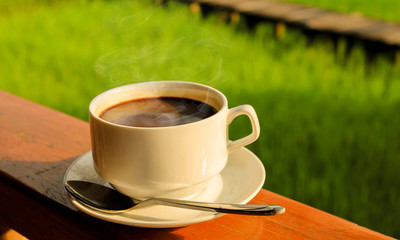 black coffee on wooden table with nature background