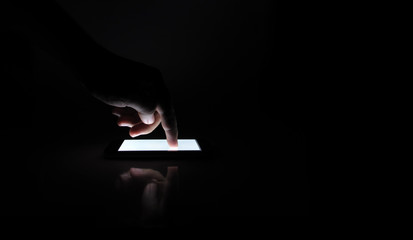 Touching smartphone in the dark.