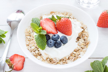 Morning healthy breakfast with muesli and berries on the white background. Top view