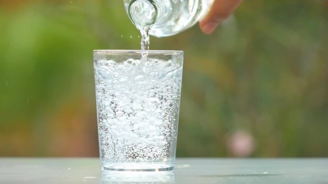 4k of Close up woman hand serving water in crystal glass on table