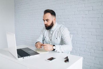Bearded man in office. Programmer.