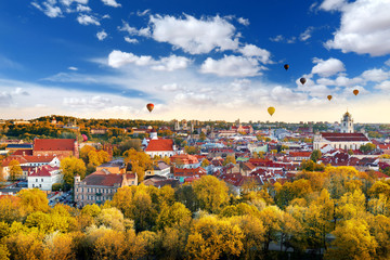 Beautiful autumn panorama of Vilnius old town with colorful hot air balloons in the sky