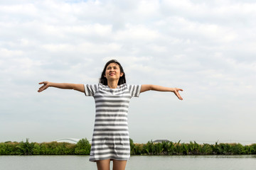 Fototapeta na wymiar beautiful asian woman standing and relax near lake,