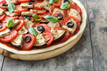 Vegetarian pizza with eggplant, tomato, black olives, oregano and basil