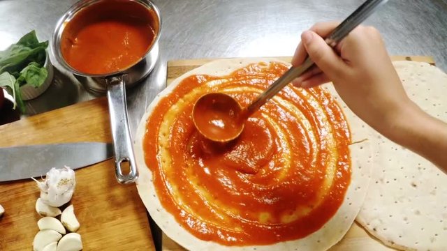 Hand of chef preparing pizza