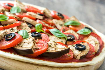 Vegetarian pizza with eggplant, tomato, black olives, oregano and basil