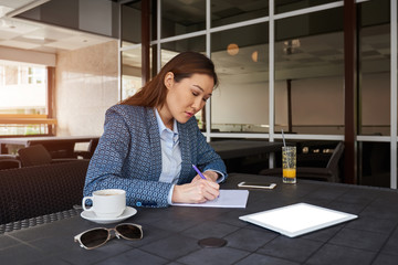 Female professor of the University is working on a doctoral thesis using contemporary device. Skilled businesswomen making plans with respect to his corporate.
