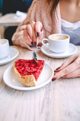 woman eating berry dessert with a spoon in  coffee shop