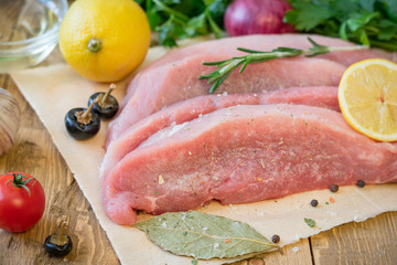 Sliced raw pork with spices on a rustic table.