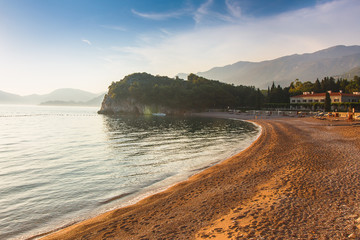 View of a rocky cliff near the Mediterranean sea and beach. Milocer Park. Coast Budva Riviera. Montenegro.