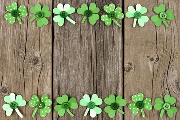 St Patricks Day double border of handmade paper shamrocks over a rustic wood background
