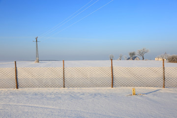 Siatka od śniegu przy drodze, krajobraz zimowy.