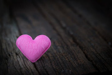 Obraz premium The pink heart for love on hard wood wiht dark tone