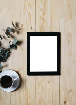 Tablet With A Clean Blank Screen Mockup Monitor With A Branch Of Eucalyptus And A Cup Of Coffee On A Wooden Background With Natural Wood Planks Top View Vertical, Mock Up Concept, Computer Technology