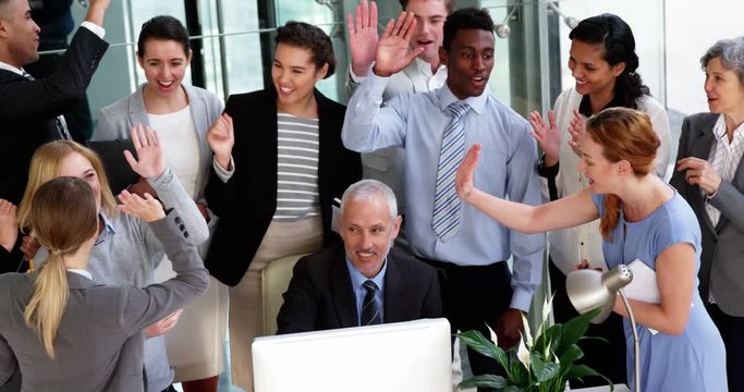Business people giving a high five to each other in office 4k