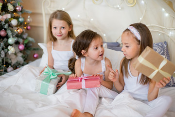 Child girls wake up in their bed in Christmas morning