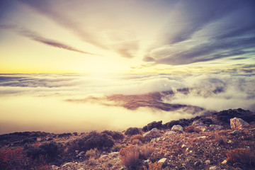Color toned scenic mountain sunset above the clouds, USA