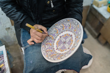 Moroccan potter at work in a pottery shop
