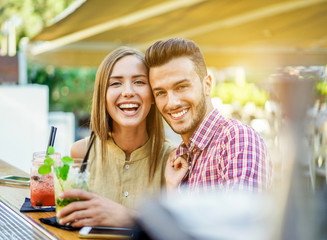Happy couple toasting cocktails in lounge disco bar