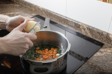 Man cooking a stew in the kitchen of her house
