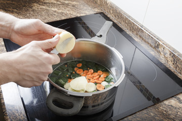 Man cooking a stew in the kitchen of her house
