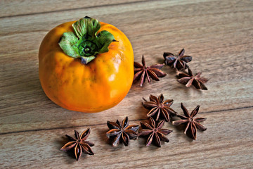 Persimmon and star anise on a wooden table
