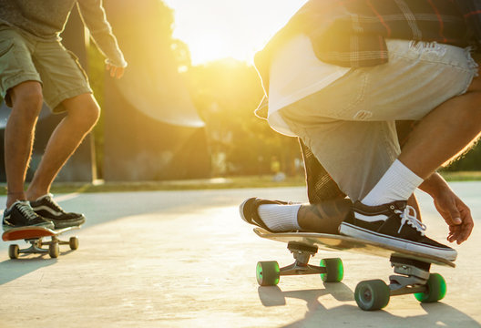 Two young skaters performing with skateboard at sunset