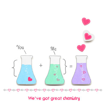 Chemistry between us / Creative valentines concept photo of laboratory flasks with hearts made of paper on white background.