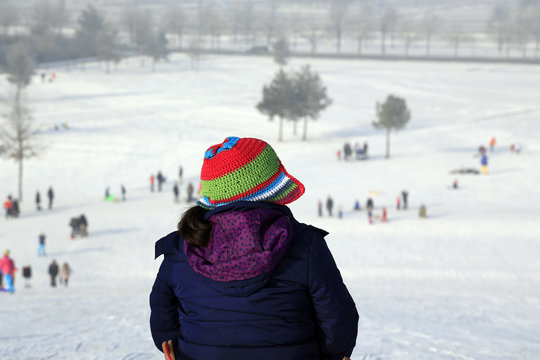Wintersport: Ein Mädchen wartet auf die nächste Talfahrt am Schlittenberg!