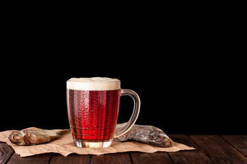 dark cold beer in a frosty mug on dark wooden table