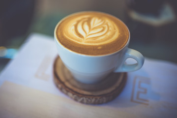 Hot coffee latte art in vintage style.