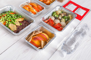 Healthy food take away in boxes, top view at wood