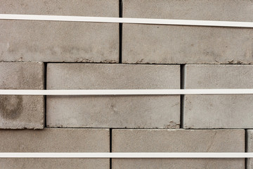 stack of concrete blocks with white packing tape. Grey bricks in a row for the production