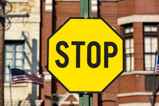 STOP -road sign with black latters on the yellow background in USA