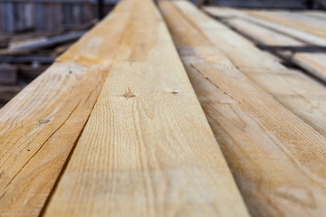 Stack of wooden terrace planks at the lumber yard. Close-up macro view with blurred background