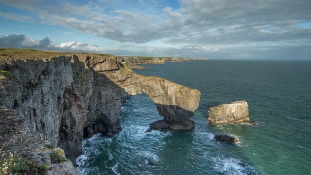 timelapse of the green bridge, a natural rock arch on the coast of pembrokeshire, wales, UK