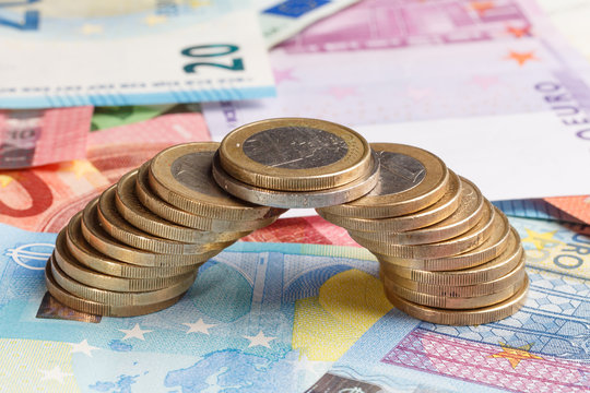 Euro Coins on banknotes building a bridge, closeup