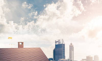 Brick house roof and modern cityscape at background