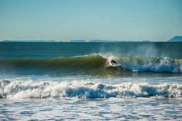 Surfer covered by the wave lip as off shore winds blow. 