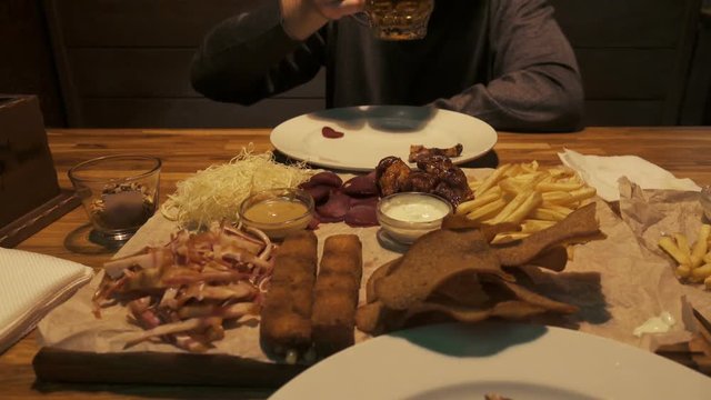 Guy in the pub drinking beer and eating snacks