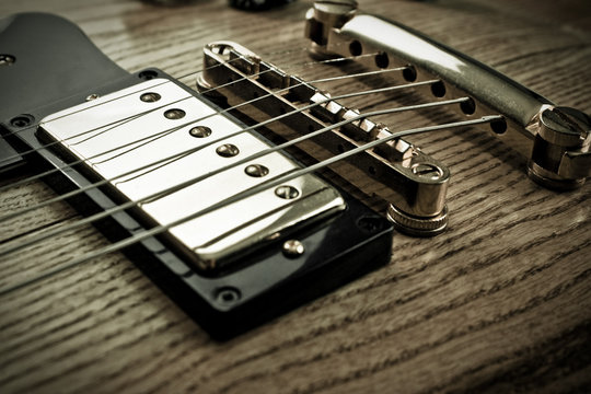 Golden pick-up, bridge and metallic strings of an electric guitar. Close up picture taken in studio.