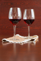 Two glasses of wine on a wooden table.
