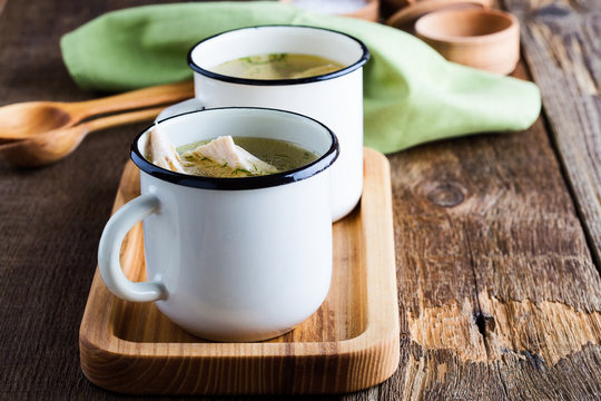 Homemade simple chicken soup in white mug