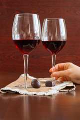 Two glasses of wine on a wooden table. Candies. Hands.