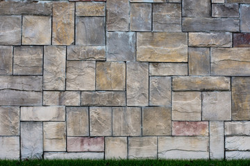 A stone wall with grass