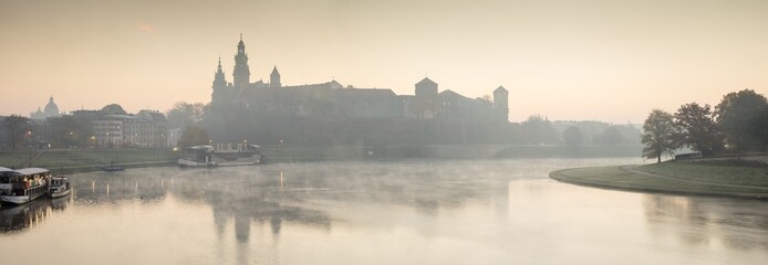 Fototapeta foggy morning on the river before castle obraz